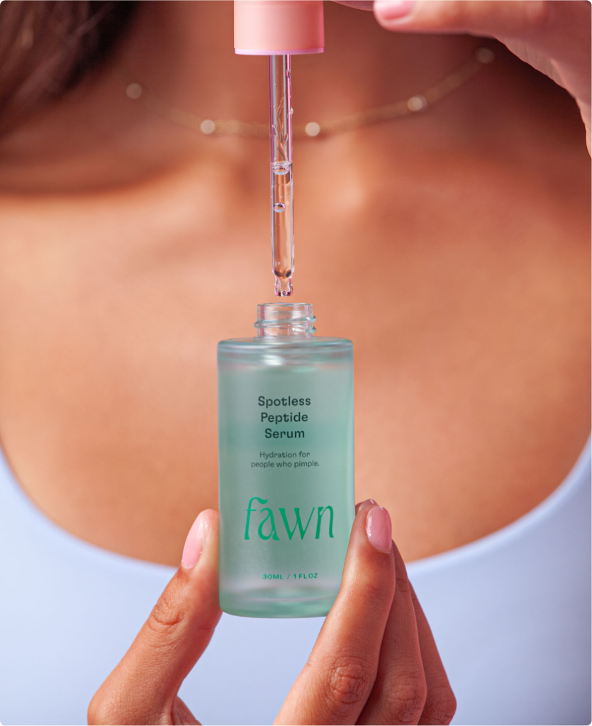 A teen girl holding a closeup of the Fawn Spotless Peptide Serum bottle.