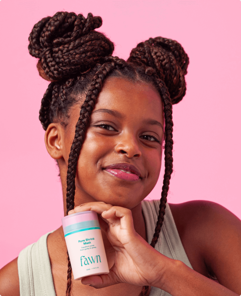 A teen girl holding a bottle of Fawn pore shrink mask product.